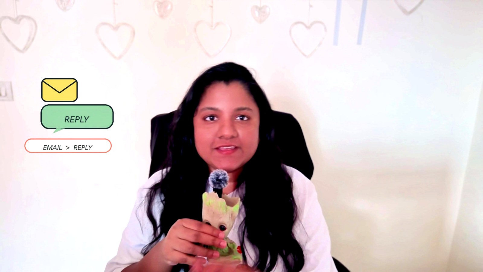 Arthi Rajendran in a white shirt holding a small Groot figure beside email reply graphics